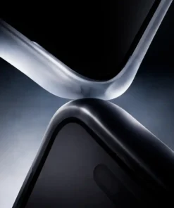 Close-up of two glossy, curved metal edges touching, forming an abstract X shape in low light.